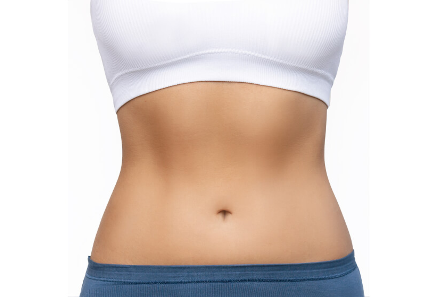 Close-up of a toned abdomen wearing a white crop top and blue shorts, reflecting wellness and aesthetic care associated with Skin & Body Med Spa's services like medical weight loss and body transformation.