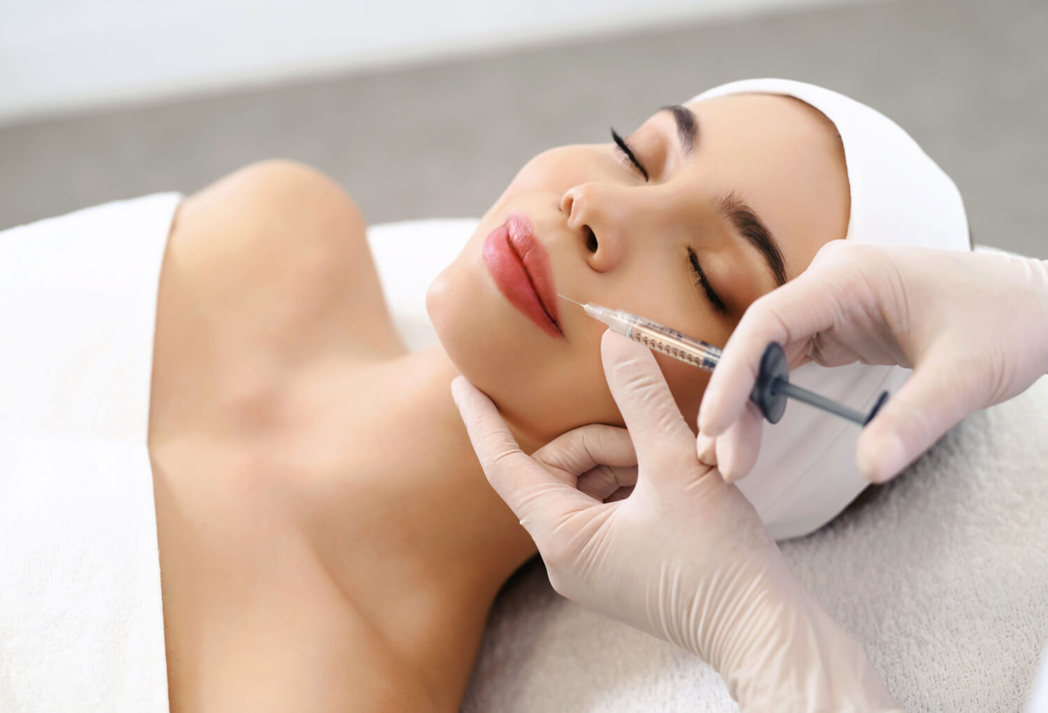 Woman receiving dermal filler injection in a spa setting, highlighting aesthetic enhancement and clinical care at Skin & Body Med Spa.